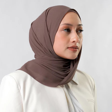 Woman wearing a brown pashmina hijab by Tantri Namirah Official against a white background