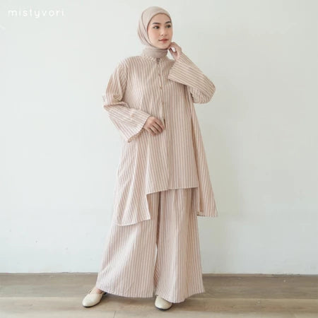 Woman wearing a light brown outfit set by Mistyvori with a hijab against a white background