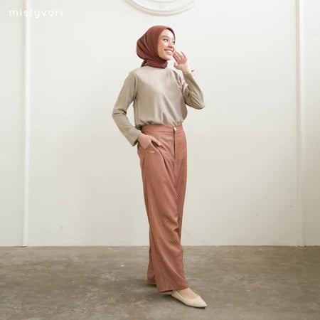 Woman wearing a beige top and brown checkered pants by Mistyvori with a hijab against a white background