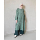 Woman wearing a green charcoal tunic with white patterns by Mistyvori and a hijab against a plain background

Seorang wanita yang mengenakan tunik berwarna hijau arang dengan motif putih dari Mistyvori dan hijab, dengan latar belakang polos