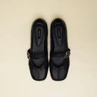 A pair of black pebbled leather Mary Jane flatshoes with silver-tone buckle straps by Cekhas, shown from a top-down view on a light beige background.