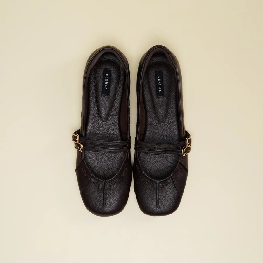 A pair of brown leather Mary Jane flatshoes with gold-tone buckle straps, shown from a top-down view on a light beige background. The brand name 'Cekhas' is visible on the insole of each shoe.