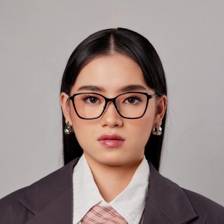 A person wearing HSF Elora eyewear with a cateye shape, made of titanium and acetate, in a professional setting.