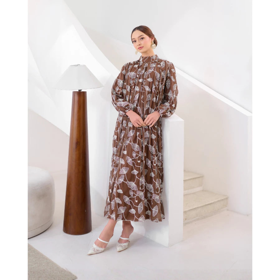 Woman in a brown floral dress by Kasa Heritage standing in a modern interior setting.