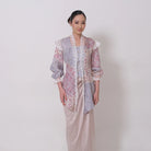 A woman wearing a traditional batik viscose kebaya by Kartinis Label with lace details and a keyhole front neckline in a misty print.