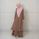 Woman wearing a dark brown tunic with a pink hijab against a plain background

Seorang wanita mengenakan tunik berwarna cokelat tua dengan hijab berwarna pink di latar belakang polos
