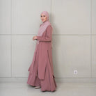 Woman wearing a pink tunic and hijab against a plain background

Seorang wanita mengenakan tunik berwarna pink dan hijab di depan latar belakang polos