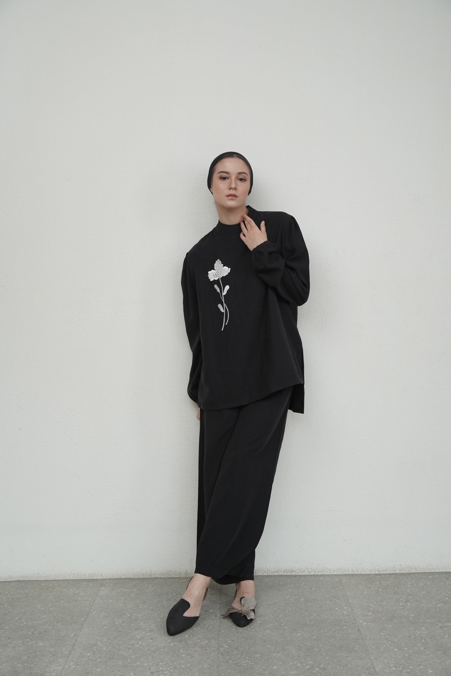 Woman wearing black outfit set from Glashka with flower design