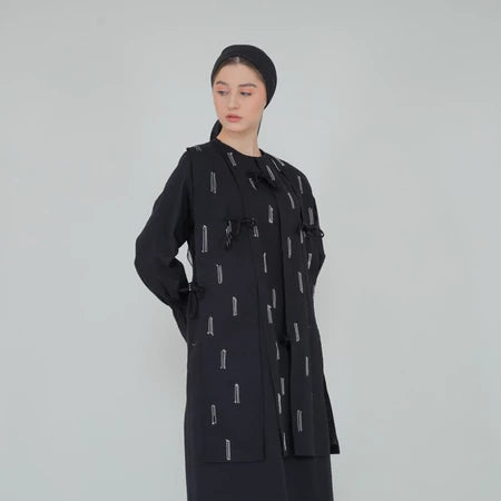 A woman wearing a black tunic dress with geometric patterns

Seorang wanita memakai tunik berwarna hitam dengan geometric patten