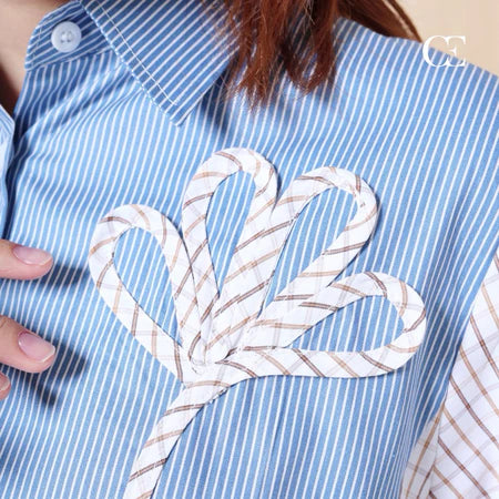 Blue and white striped shirt with a decorative bow design on the chest by Casa Elana.