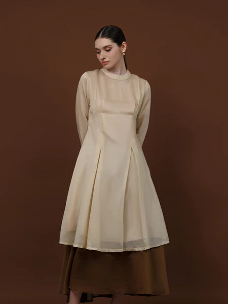 Seorang wanita memakai tunik berlengan panjang berwarna almond dari brand Kasa Heritage.