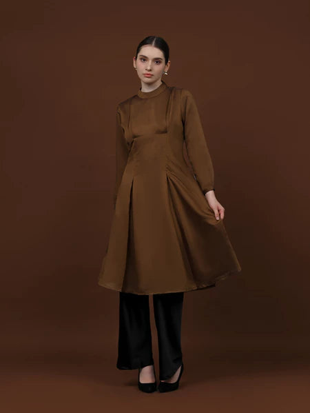 Seorang wanita memakai tunik berlengan panjang berwarna coffee dari brand Kasa Heritage.