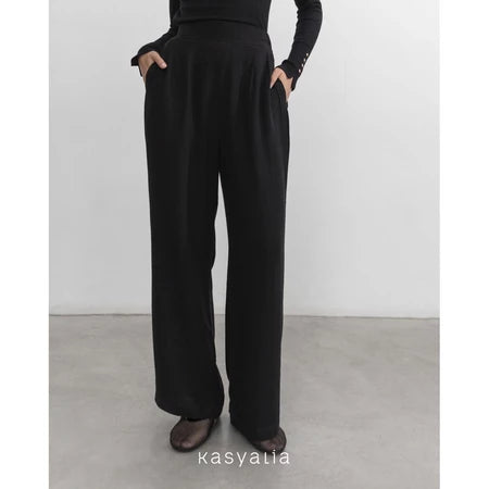 Black wide-leg pants worn by a person on a plain background with 'kasyalia' branding.