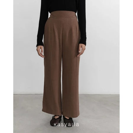 Brown wide-leg pants worn by a person on a plain background with 'kasyalia' branding.