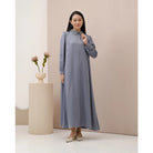 A woman wearing a blue dress with long sleeves by Kasa Heritage, featuring a mandarin collar with detail and a detachable belt.