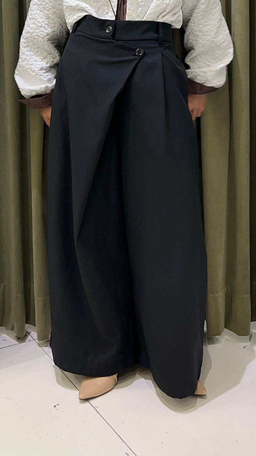 Person wearing a white top and black wide-leg Maima pants against a neutral background