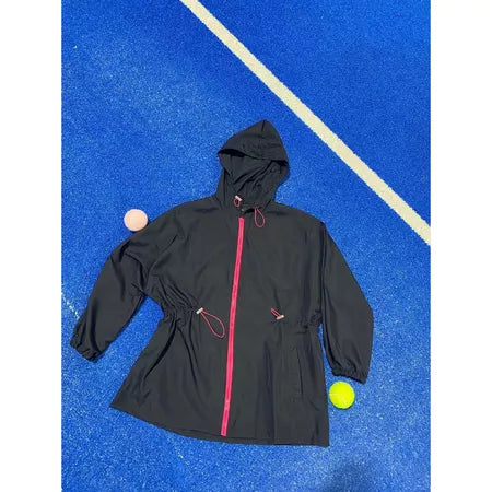 Black track jacket by Abame with pink zipper on a blue textured surface