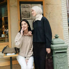 Two women standing together in front of a building with a green mailbox wearing kana top jacket by Haidee Orlin.