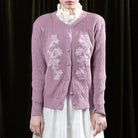 Person wearing a purple embroidered cardigan by BWBYAZ over a white outfit against a dark background