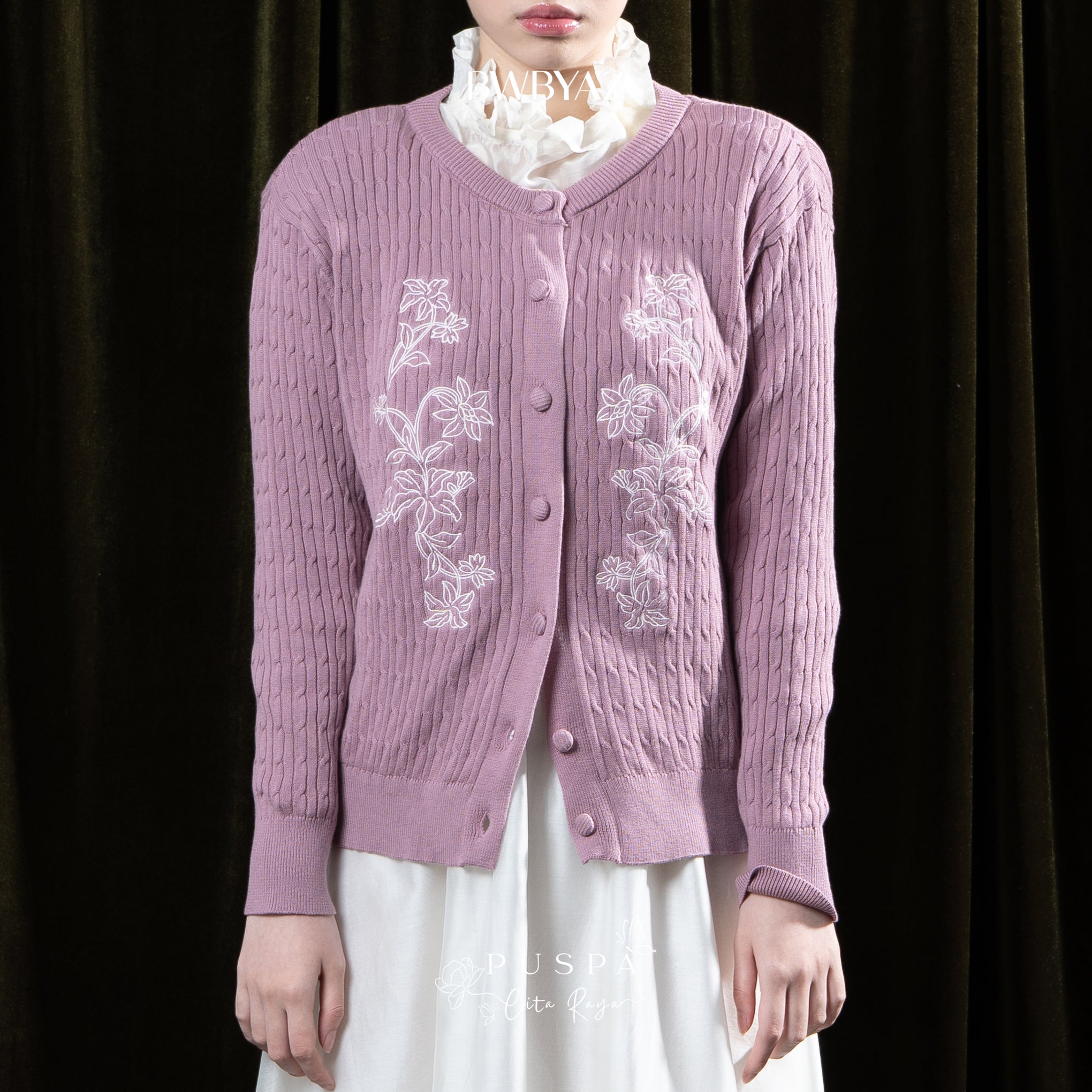 Person wearing a purple embroidered cardigan by BWBYAZ over a white outfit against a dark background