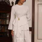 Person wearing a white blouse by Kasyalia with a gold belt in an indoor setting