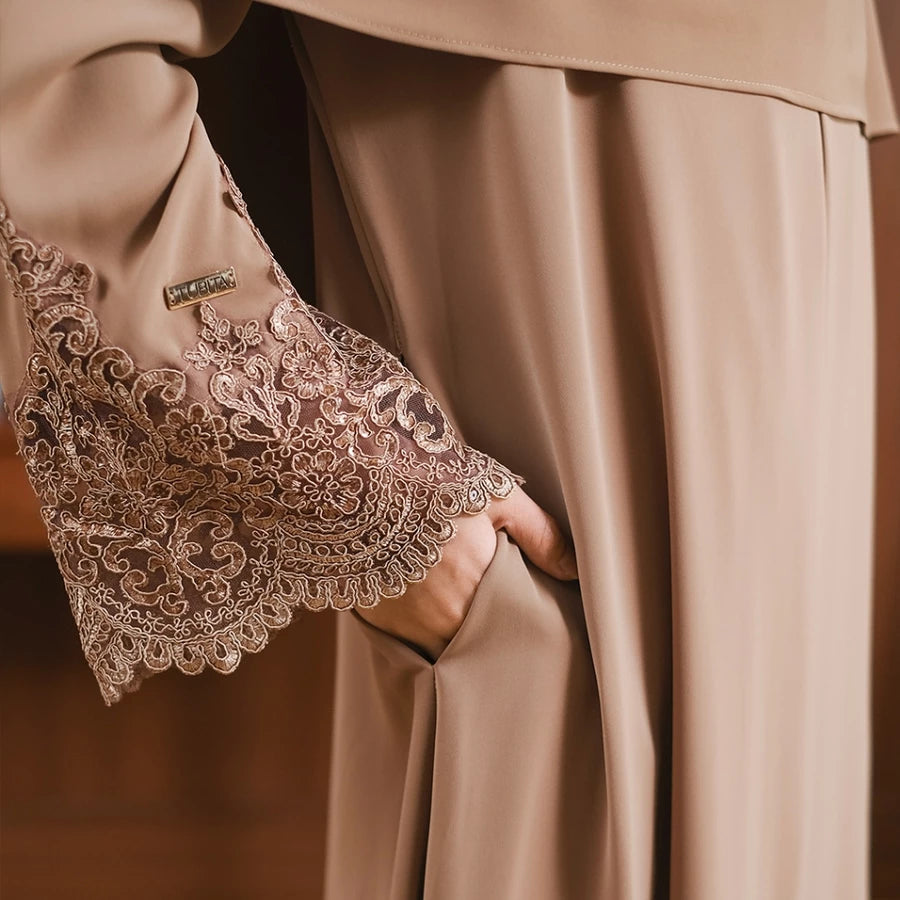 Close-up of a brown abaya with lace sleeve with intricate detailing by Tubita.