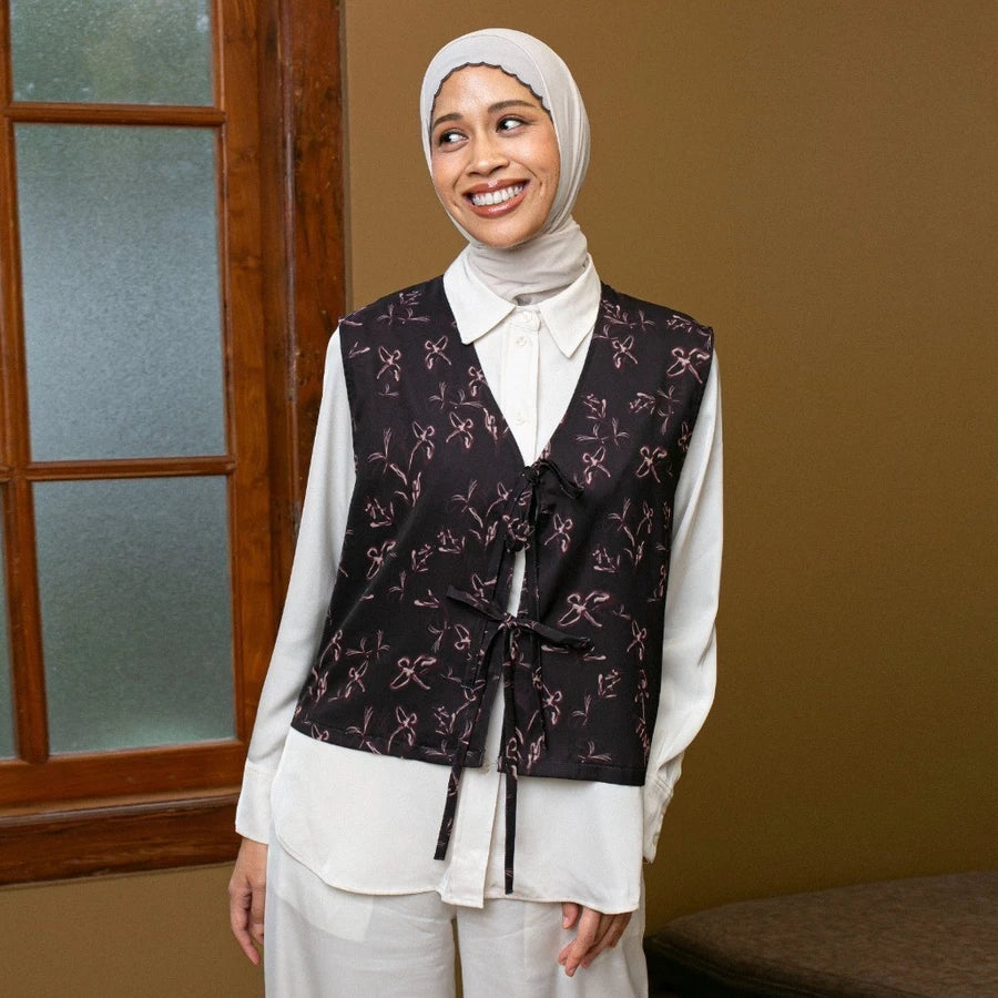 Woman wearing a patterned dark brown vest by Lozy Hijab over a white shirt in an indoor setting