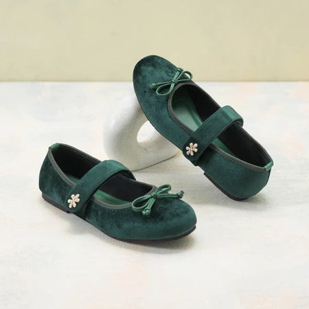 Pair of green suede flat shoes by Dianable with floral details on a white background