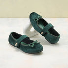 Pair of green suede flat shoes by Dianable with floral details on a white background