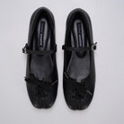 A pair of black Mary Jane ballet flatshoes by Cekhas with matching ribbon bows and small gold-tone buckle details, displayed on a light gray background.