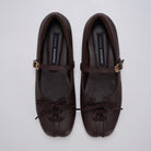 A pair of brown Mary Jane ballet flatshoes by Cekhas with matching ribbon bows and small gold-tone buckle details, displayed on a light gray background.