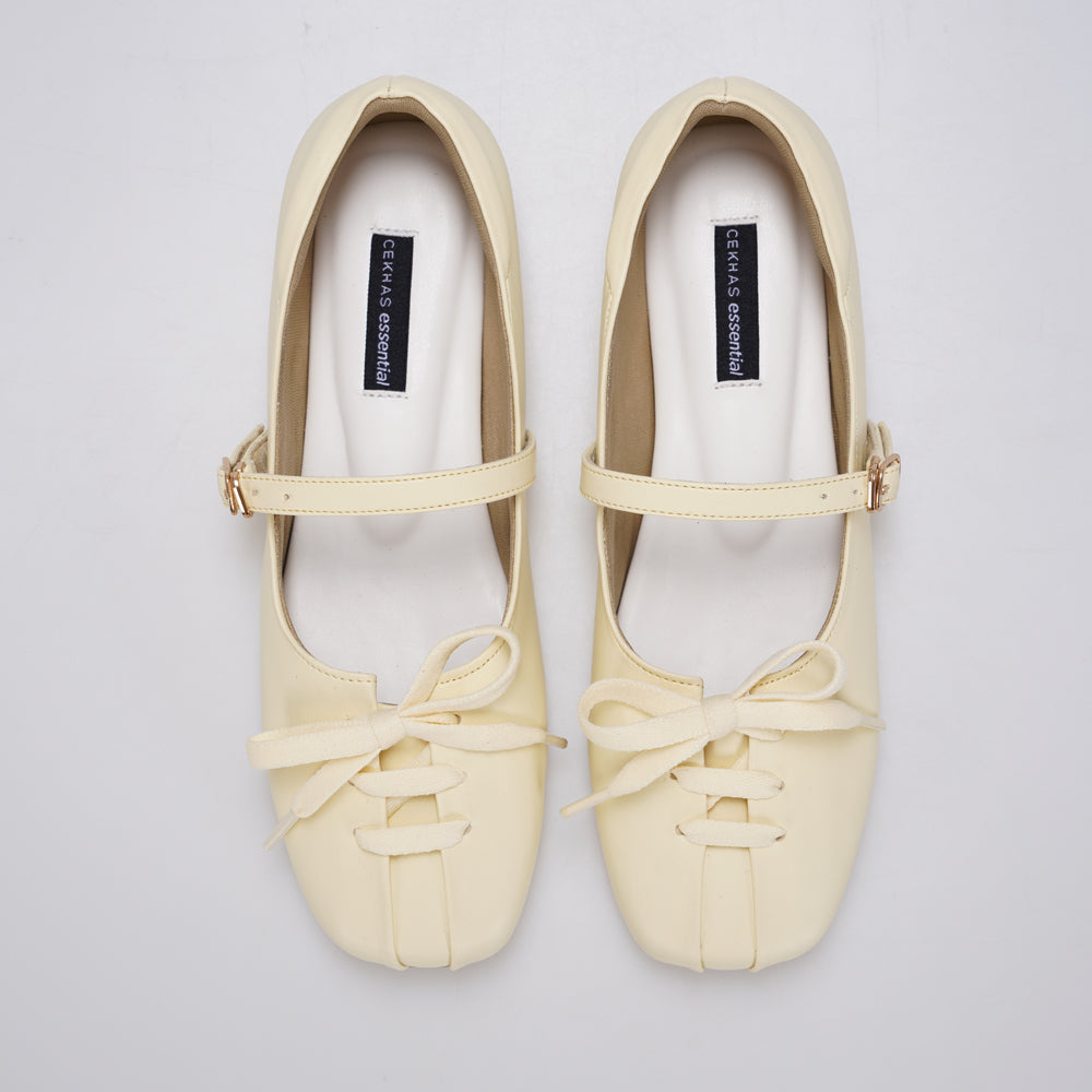 A pair of butter yellow Mary Jane ballet flatshoes by Cekhas with matching ribbon bows and small gold-tone buckle details, displayed on a light gray background.