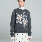 Person wearing a dark gray cardigan by BWBYAZ with floral design on a plain background