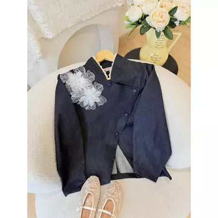 Black jeans blazer with white floral details by Haidee Orlin on a chair