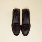 A pair of dark brown leather penny loafers flatshoes with a pebbled texture, shown from a top-down view on a light cream background. The brand name 'Cekhas' is visible on the insoles.