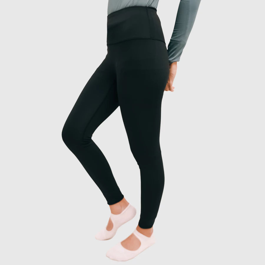 Person wearing black leggings by HIA on a light gray background