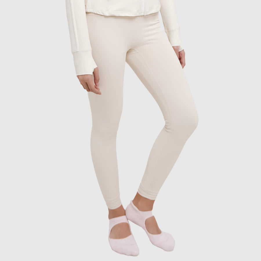 Person wearing cream leggings by HIA and pink socks on a white background