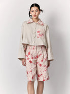 Model wearing a beige jacket with floral details by Studio Tui on a white background