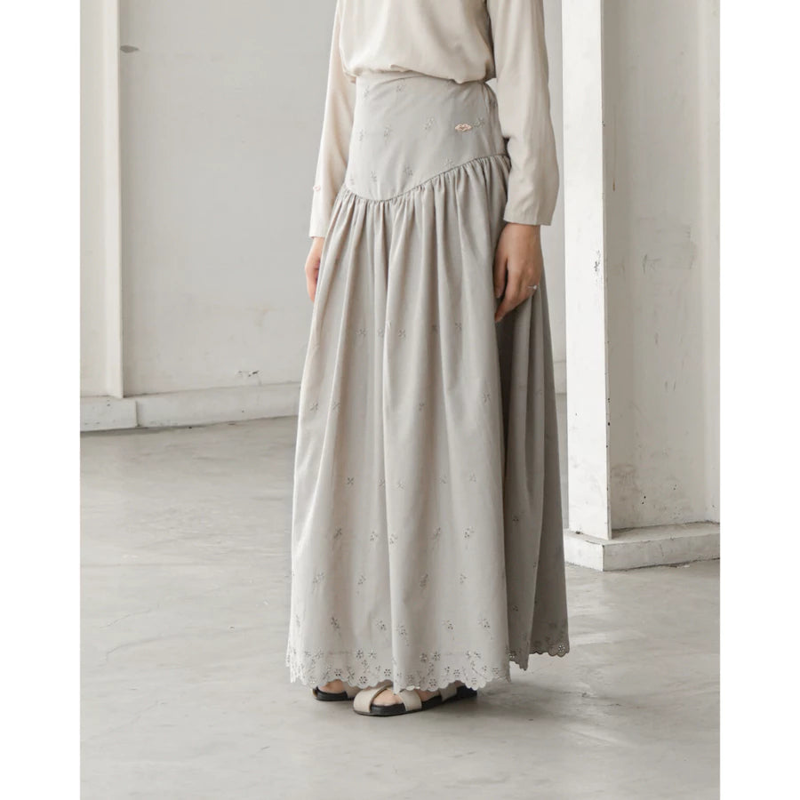 Person wearing a long light gray skirt by Mistyvori in a minimalistic setting