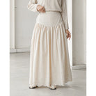 Person wearing a long beige skirt by Mistyvori and top in a minimalistic room.