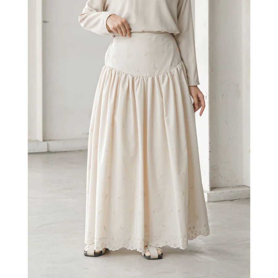 Person wearing a long beige skirt by Mistyvori and top in a minimalistic room.