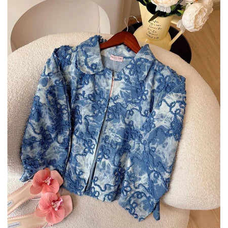 Sky blue floral-patterned jacket from Haidee Orlin on a chair with flowers around