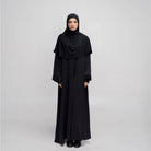 Person wearing a black abaya by Tubita on a white background