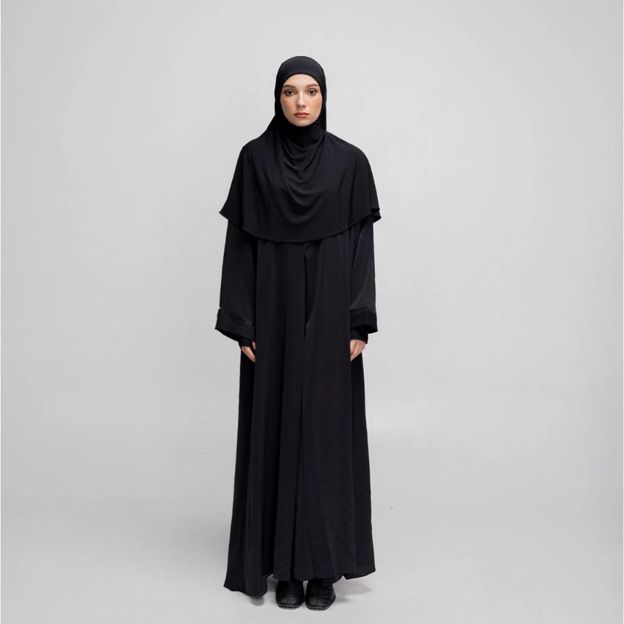 Person wearing a black abaya by Tubita on a white background