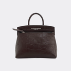 Brown crocodile textured mini-sized handbag with a visible brand name Aesthetic Pleasure on a light gray background