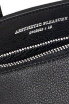Black grain leather bag with silver zipper and 'Aesthetic Pleasure' text on a white background