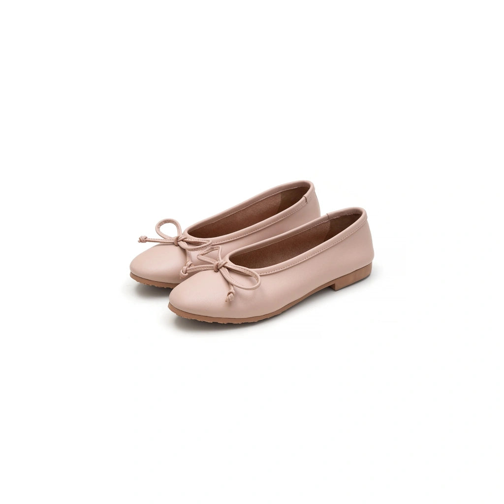 Pair of pink flat shoes by Cajsa with a bow on a white background