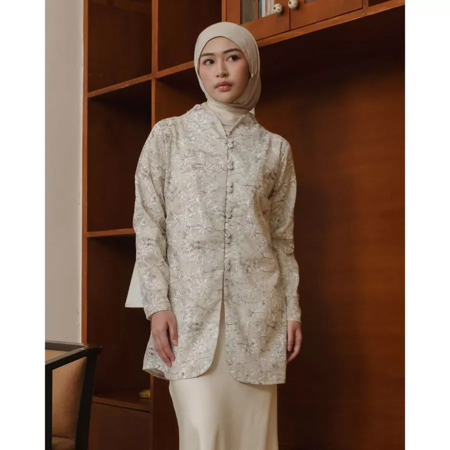Woman wearing a patterned beige tunic and hijab standing in a room with wooden furniture.

Seorang wanita mengenakan tunik bermotif berwarna beige dan hijab berdiri di dalam ruangan dengan perabotan kayu.