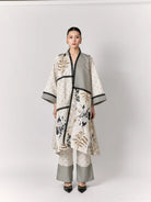 Woman wearing a stylish outer with a floral pattern by Studio Tui on a white background