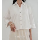 Person wearing a white button-up shirt with rolled-up sleeves on a plain background, with 'kasyalia' branding.